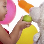 Toddler feeds teddy bear