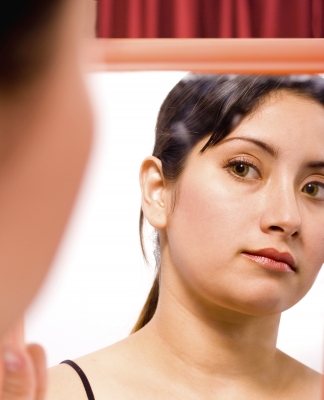 woman looking into mirror
